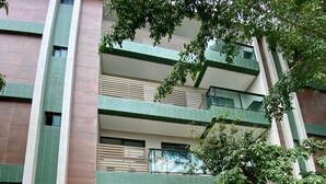 A multi-story building with a staircase leading to the entrance. - Flat a 120 metros das Piscinas Naturais (Ipojuca)