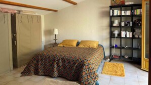 Een slaapkamer met een bed, een boekenkast en een deur.