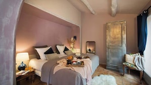 Une chambre à coucher avec un lit, une table de chevet, une lampe et un miroir.