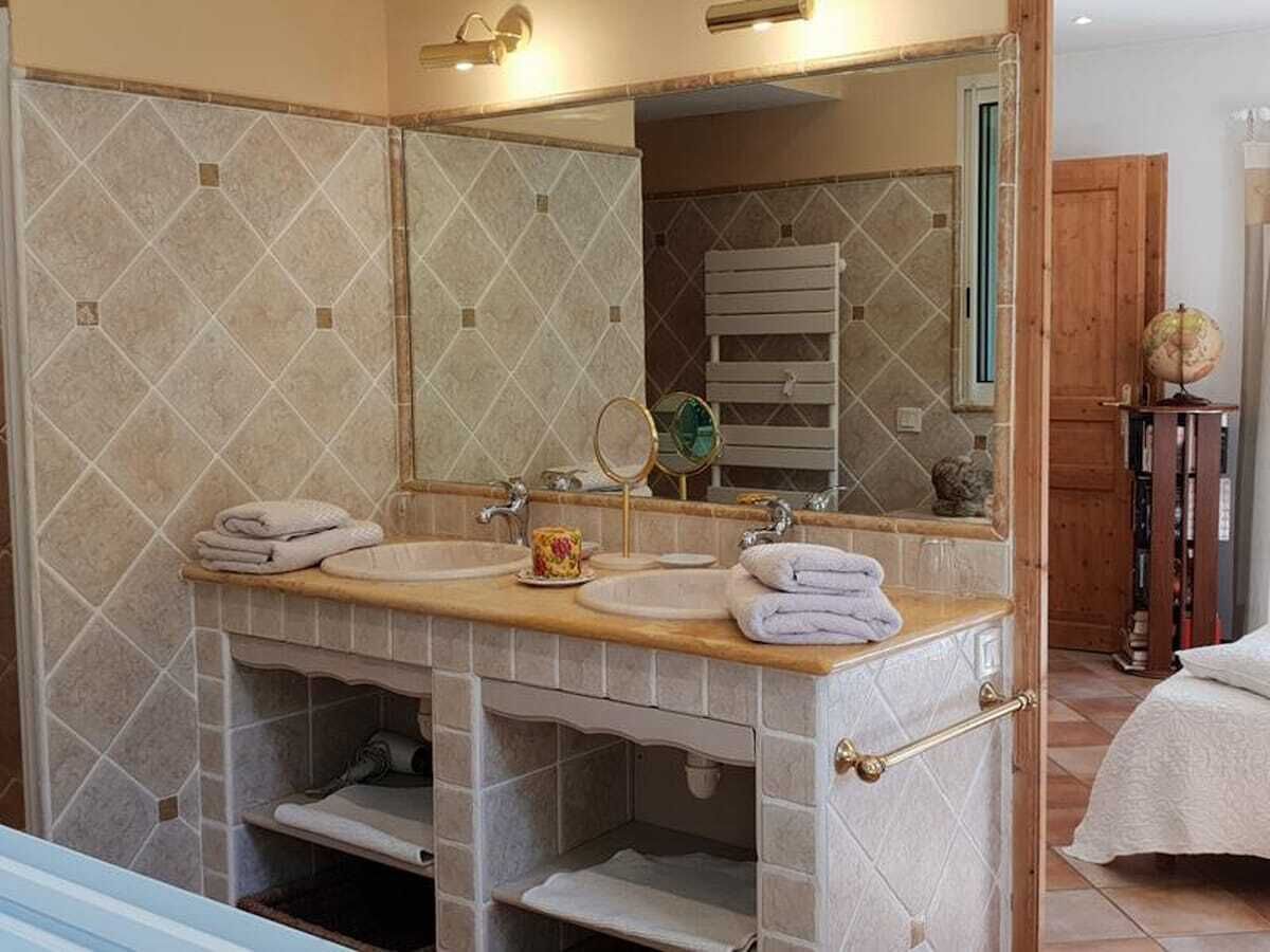 A bathroom with two sinks, a mirror, and a towel rack.