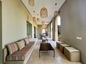 Ein geräumiger Flur mit einer langen Couch, einem Couchtisch und mehreren Sitzgelegenheiten.