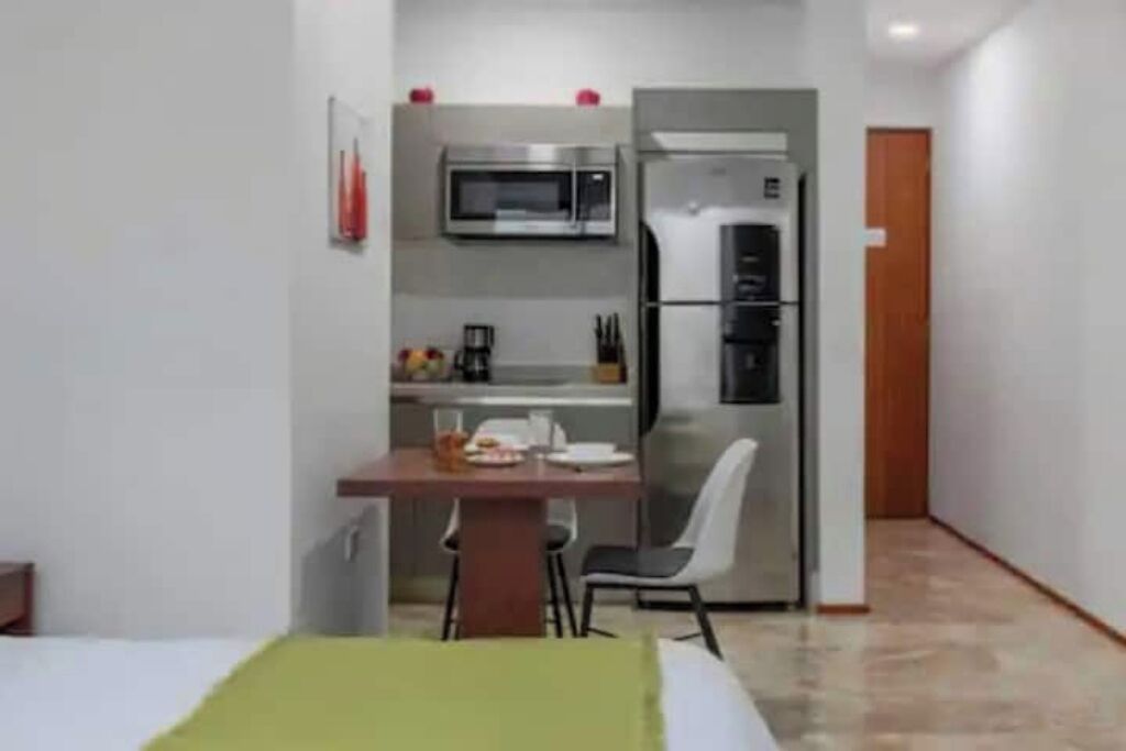 A compact kitchen with a microwave, refrigerator, and dining area.