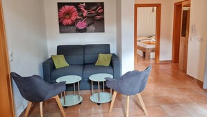 A living area with a sofa, two small tables, and two chairs. - Apartment With Mountain & Slope View (Bad Kleinkirchheim)