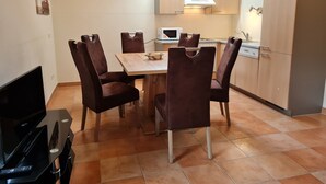 A compact kitchen with a dining table and chairs, a microwave, and a cabinet. - Apartment With Mountain & Slope View (Bad Kleinkirchheim)