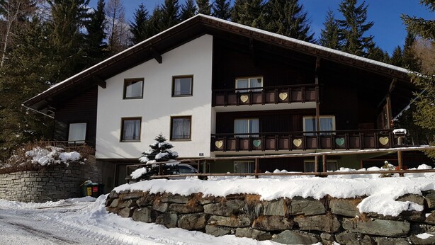 A multi-story wooden building with balconies, surrounded by snow and trees. - Apartment Near Romerbad Thermal Spa (Bad Kleinkirchheim)