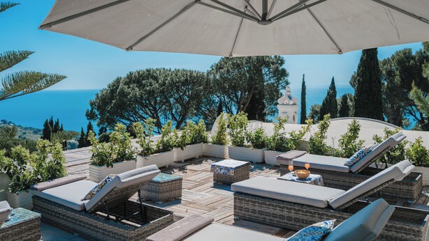 A rooftop terrace with lounge chairs, a large umbrella, and potted plants. - Villa Margherita by My Villa Collection (Anacapri)