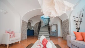 A spacious living area with a staircase leading to a stone-walled upper level. - Villa Margherita by My Villa Collection (Anacapri)