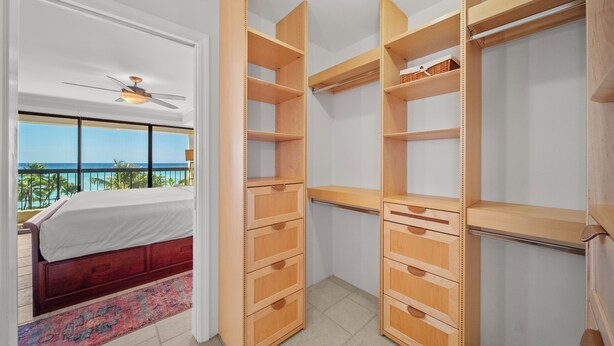 Une chambre à coucher avec un lit, une armoire en bois et une vue sur l’océan.