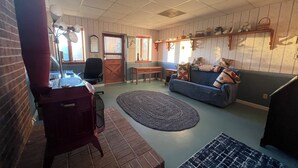 Una sala de estar acogedora con un sofá azul, una mesa de centro de madera y una alfombra estampada.