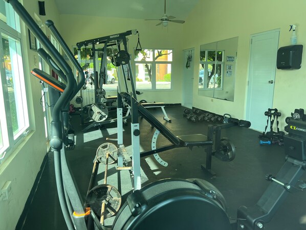 A gym with various exercise equipment, including a bench press, dumbbells, and weight plates. - 2 BR Beach Resort Apt with WiFi and access to the beach (Medianía Alta)