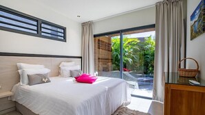 Un dormitorio con una cama grande, vistas al exterior y un ventanal corredera.