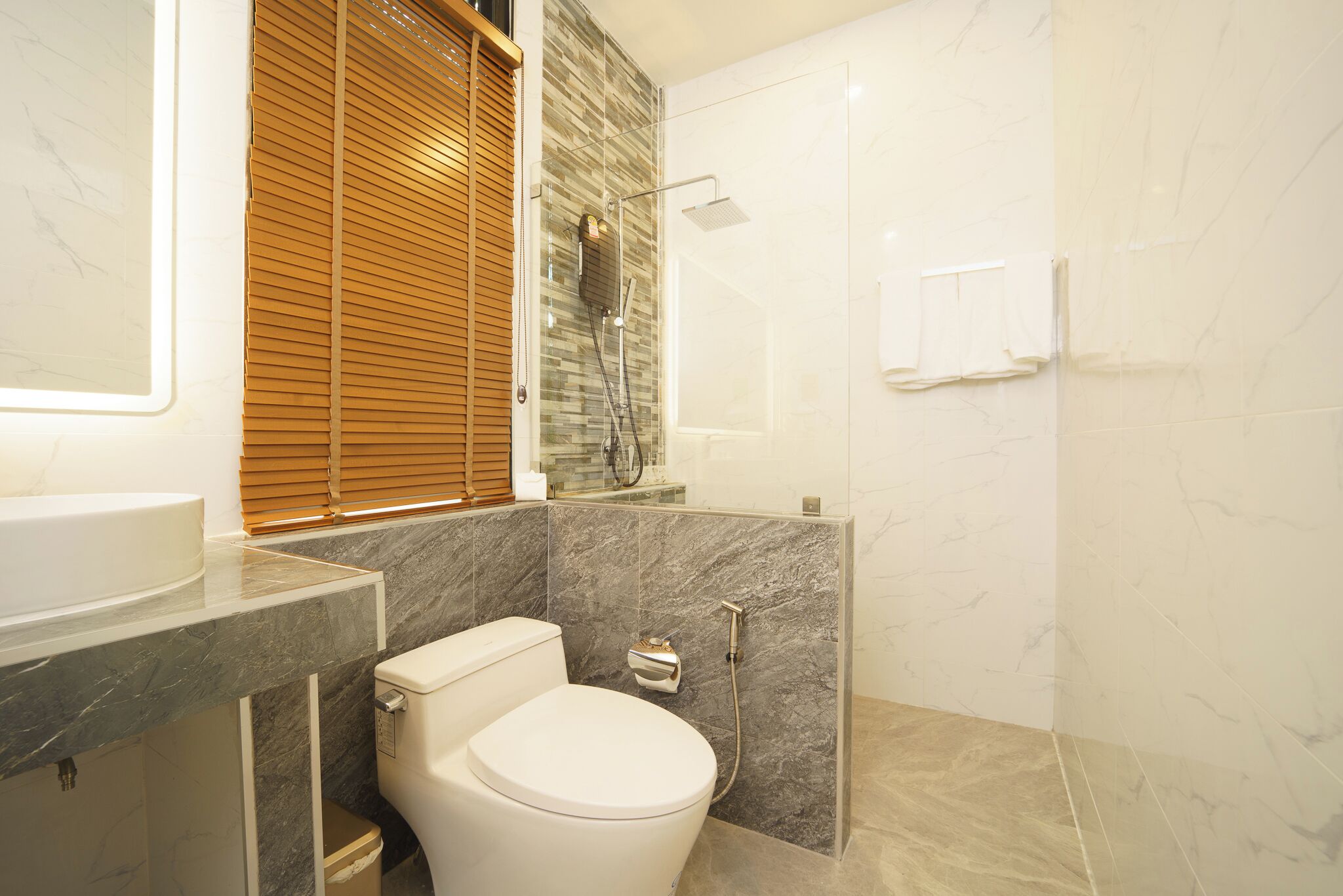 A modern bathroom with a toilet, sink, and shower area.