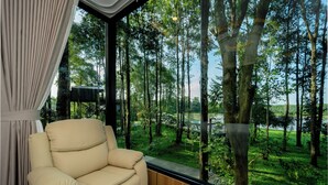 A room with a large window overlooking a forested area.