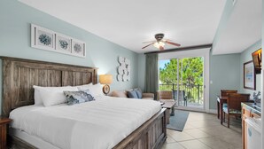 Un dormitorio con una cama grande, un ventilador de techo y vistas al exterior.