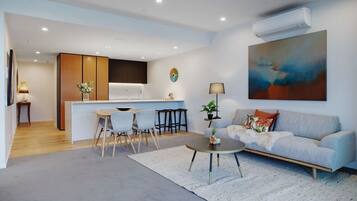 A modern living room with a sofa, coffee table, and dining area.
