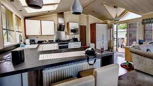 Une cuisine moderne dotée d’un îlot central, d’appareils électroménagers intégrés et d’un coin repas avec un canapé.