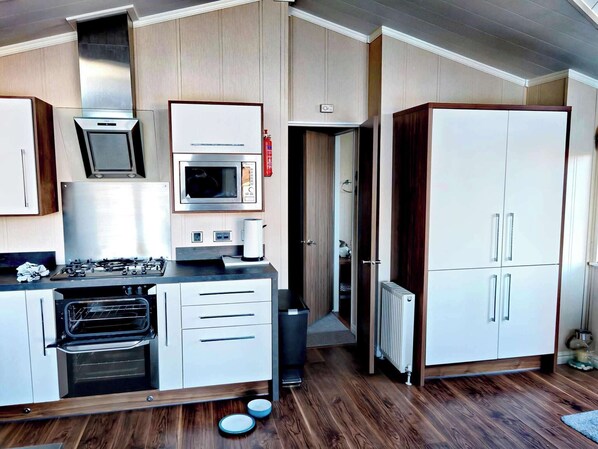 Cocina compacta con microondas, estufa, horno y armarios.