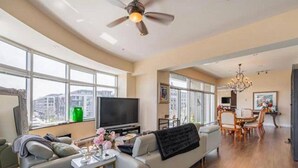 A modern living room with a sofa, TV, and dining area. - Sleeps6-apartment-parking-balcony-patio (Madrid)