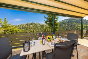 Een gedekte tafel met uitzicht op een bebost berglandschap.
