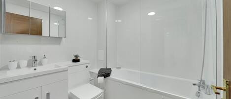A modern bathroom with a white sink, toilet, and bathtub.