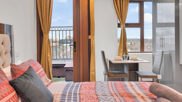 Un dormitorio con cama, escritorio y silla.