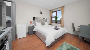 A modern bedroom with a bed, a desk, and a chair. - London City Apartment in Ilford (Ilford)