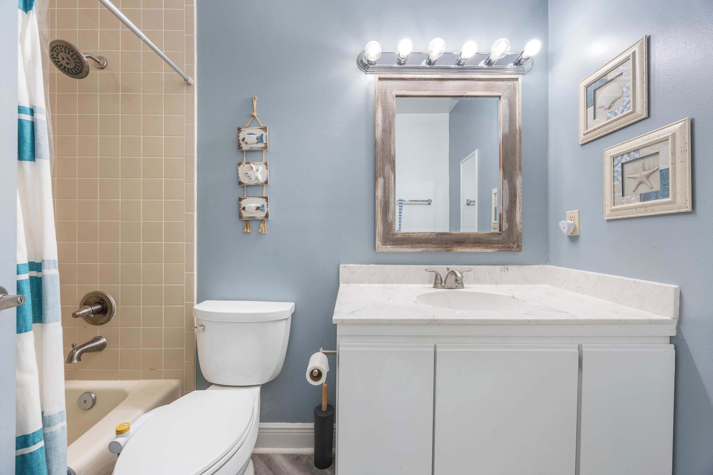 A bathroom with a toilet, sink, and shower.