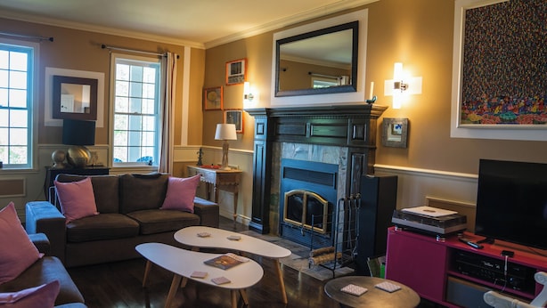 Een woonkamer met een open haard, een bank, twee salontafels en een televisie.