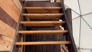 A wooden staircase with a metal handrail inside a tent-like structure. - Moonshiner Tree Dome is rustic luxury with big, beautiful panoramic views. (Hico)