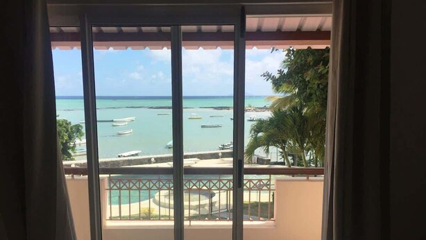 Een balkon met uitzicht op zee en boten.