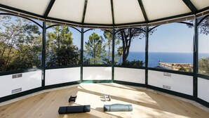Une pièce dotée d’une grande fenêtre en verre, d’un plancher en bois et d’un plafond blanc.