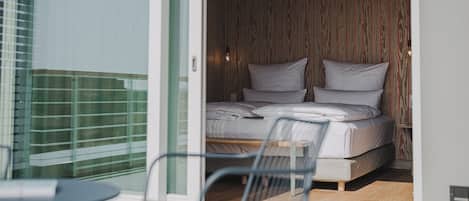 A bedroom with a bed, a chair, and a table.