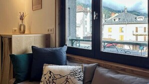 A cozy seating area with a view of a town through a large window.