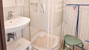 A bathroom with a glass-enclosed shower, a sink, and a step stool. - Étoile Front de Neige (Demi-Quartier)