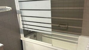 A bathroom with a bathtub, a toilet, and a trash can. - Mountain Apartment With Terrace (Saint-Chaffrey)