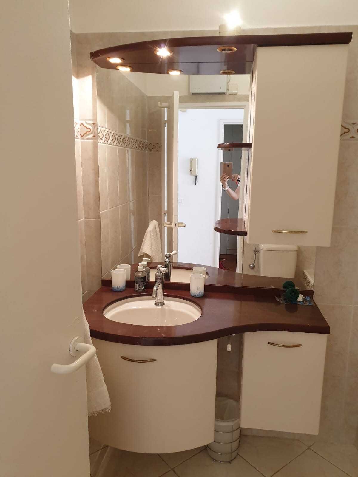 A bathroom with a sink, mirror, and vanity cabinets.