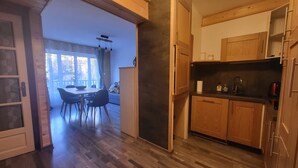 A modern kitchen with wooden cabinets and a dining area with a table and chairs.