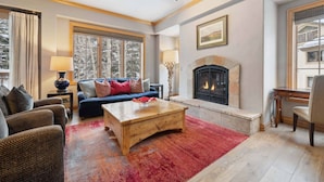 A cozy living room with a fireplace, a sofa set, and a coffee table.