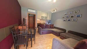 Una sala de estar con comedor, cocina y pasillo.
