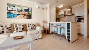 A modern living room with a sofa, a coffee table, and a painting on the wall.