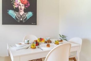A dining table with plates, cutlery, and a glass of juice.
