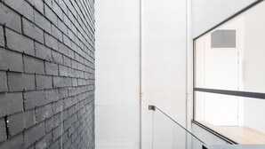 A modern building exterior with a grey brick wall and a large window. - GuestReady - A peaceful ambience in Porto (Porto)