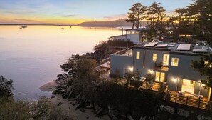 A coastal property with a modern design, featuring a large building with multiple windows and a flat roof.
