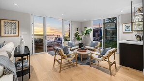 A modern living room with a large sliding glass door leading to a balcony, a round coffee table, and a sofa.