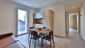 A modern kitchen with a dining area, a bench, and a view of the outside. - Apho Apartment-Hotel (Rimini)