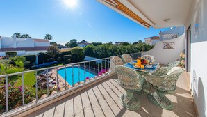 A balcony with a pool, outdoor furniture, and a clear view of the surrounding area.