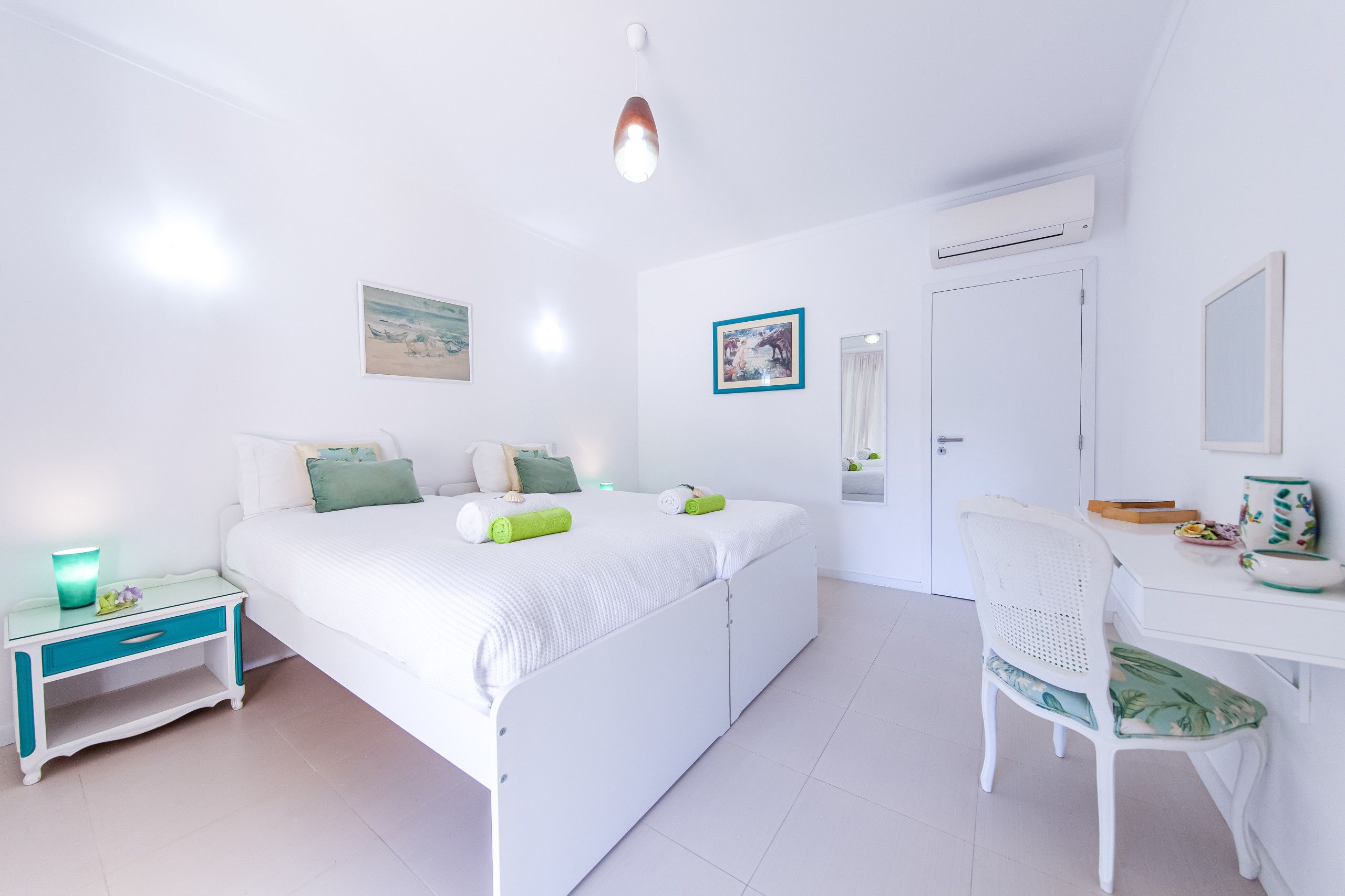 Une chambre à coucher comprenant un lit, une table de chevet, une chaise, un bureau et un miroir.