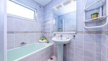 Un baño con bañera, lavamanos y ducha.