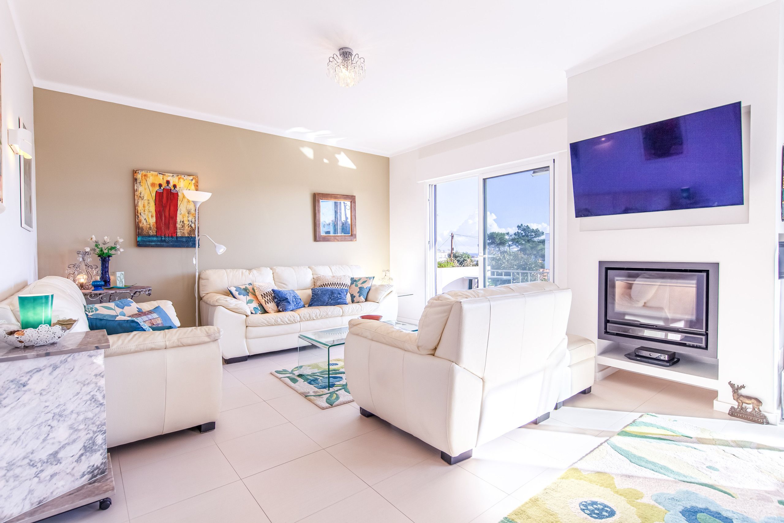 Una sala de estar moderna con un sofá blanco, un televisor de pantalla plana y una chimenea.