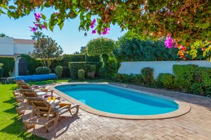 A swimming pool with lounge chairs and a brick patio. - Villa Blue Bay (Albufeira)